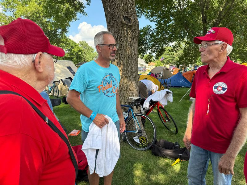 Veterans Tom Arends of Milford, and Henry Siemers of West Okoboji talk with Dan Knoeck of Marshallville, Minn., about their Honor Flight experience. Knoeck plans to go on the flight with his father in September.