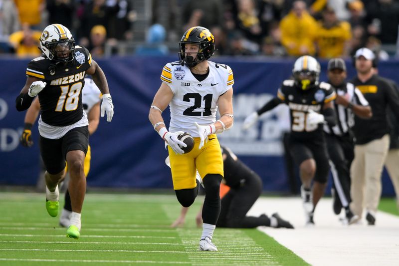 Dec 30, 2024; Nashville, TN, USA; Iowa Hawkeyes wide receiver Kaden Wetjen (21) returns a kickoff for a touchdown against the Missouri Tigers during the first half at Nissan Stadium. Mandatory Credit: Steve Roberts-Imagn Images