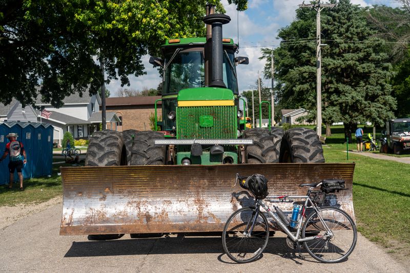 A bike leans against a John Deere tractor during the third day of RAGBRAI on Tuesday, July 22, 2025, in Woden.