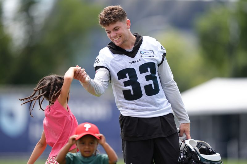 Philadelphia Eagles defensive back Cooper DeJean (33) plays with the children of running back Saquon Barkley during training camp at NovaCare Complex on July 23, 2025, in Philadelphia.