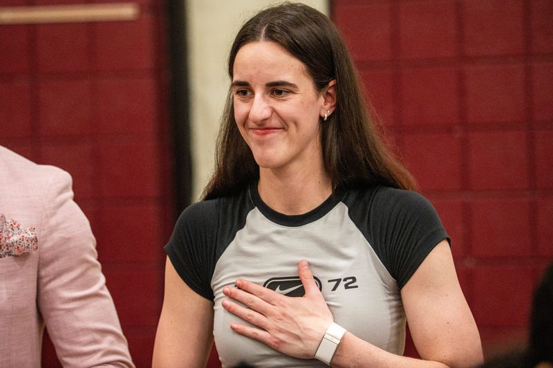Basketball Star Caitlin Clark smiles while handing out backpacks to students during a ribbon cutting for a new outdoor basketball court at McCombs Middle School with the Caitlin Clark foundation on July 28, 2025, in Des Moines. Clark’s foundation also gave away free back-to-school supplies to 500 students.