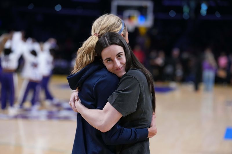 Aug 5, 2025; Los Angeles, California, USA; Indiana Fever guard Caitlin Clark (right) embraces guard Lexie Hull during the game against the LA Sparks at the Crypto.com Arena. Mandatory Credit: Kirby Lee-Imagn Images