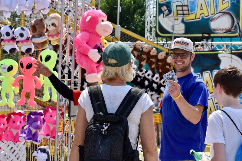 Brendan Eilander shows Alana Zehring a fidget spinner after a round of carnival games at the Iowa State Fair midway on Friday, August 8, 2025
