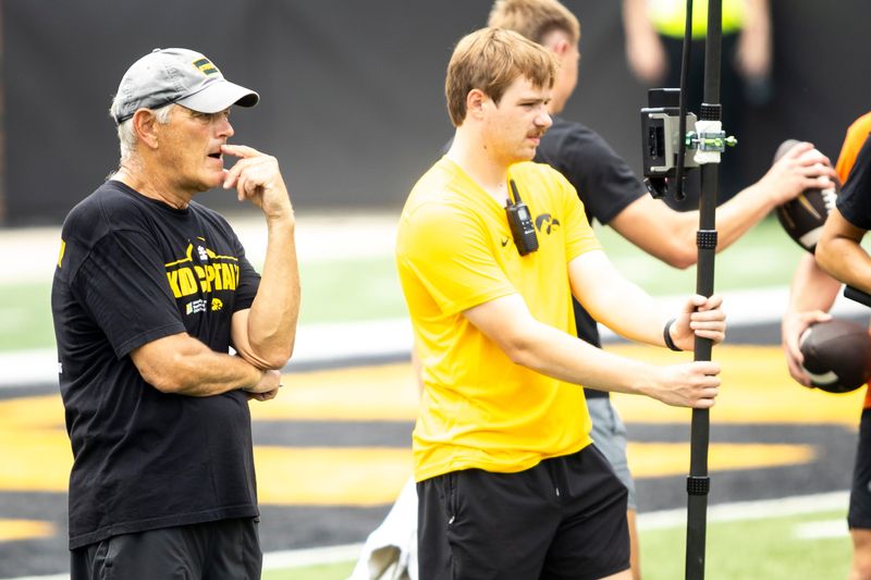 Aug 9, 2025; Iowa head coach Kirk Ferentz, left, looks on during the Hawkeyes Kids Day NCAA football open practice at Kinnick Stadium in Iowa City, Iowa. Mandatory Credit: Joseph Cress for the Des Moines Register
