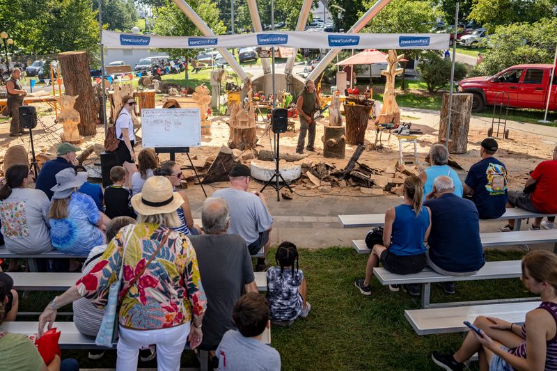 Attendees watch as Gary Keenan of Des Moines carves a Garden Gnome at the MidAmerican Energy Wind Turbine and Education Center during the Iowa State Fair, Aug. 13, 2025.