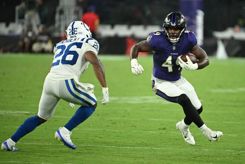 Aug 7, 2025; Baltimore, Maryland, USA; Baltimore Ravens linebacker Jay Higgins IV (49) runs back an interception in front of Indianapolis Colts running back Khalil Herbert (26) during the fourth quarter at M&T Bank Stadium. Mandatory Credit: Rafael Suanes-Imagn Images