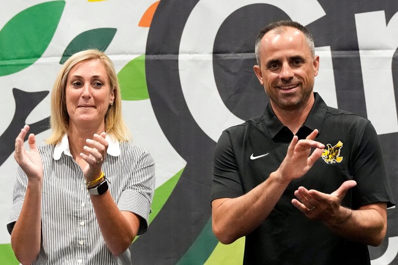 Iowa Athletic Director Beth Goetz and menâ€™s basketball coach Ben McCollum clap along to the Iowa Fight Song during Fryfest Aug. 29, 2025 at the Iowa River Landing in Coralville, Iowa.