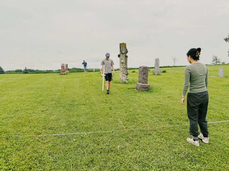 (From left) Luther College students Evan McElroy, Benson Newhouse and Rebecca Zheng used underground sensing technology to identify possible unmarked graves in pioneer cemeteries this summer.