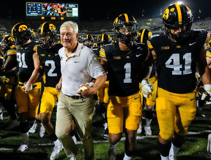 Iowa Hawkeyes head coach Kirk Ferentz runs off the field with his players after becoming the winningest coach in Big Ten history, passing Woody Hayes, with a win over the Massachusetts Minutemen Sept. 13, 2025 at Kinnick Stadium in Iowa City, Iowa.