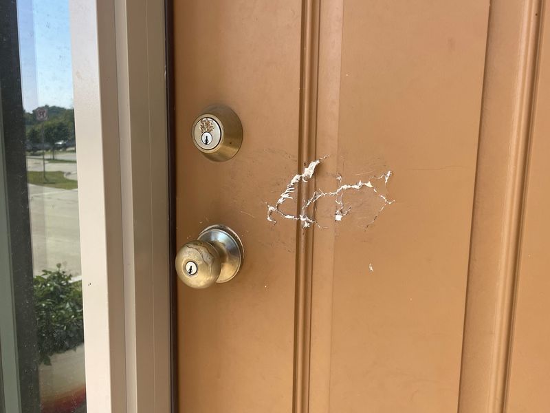 Damage is visible on the front door of Ian Roberts’ home, where neighbors say federal agents forced entry during Friday, Sept. 26 night’s search.