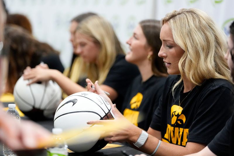 Kylie Feuerbach and other Iowa women's basketball players sign autographs for fans during Fryfest Aug. 29, 2025 at the Iowa River Landing in Coralville, Iowa.