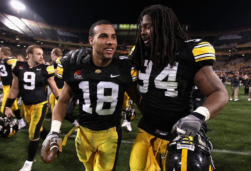 TEMPE, AZ - DECEMBER 28: Defensive player of the game Micah Hyde #18 and Adrian Clayborn #94 of the Iowa Hawkeyes walk off the field after defeating the Missouri Tigers in the Insight Bowl at Sun Devil Stadium on December 28, 2010 in Tempe, Arizona. The Hawkeyes defeated the Tigers 27-24. (Photo by Christian Petersen/Getty Images)