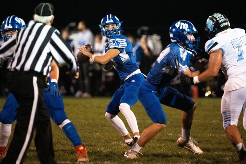 Van Meter's Henry Lounsbury looks to attempt a pass during a first round playoff football game at Van Meter High School on Friday, Oct. 24, 2025, in Van Meter.