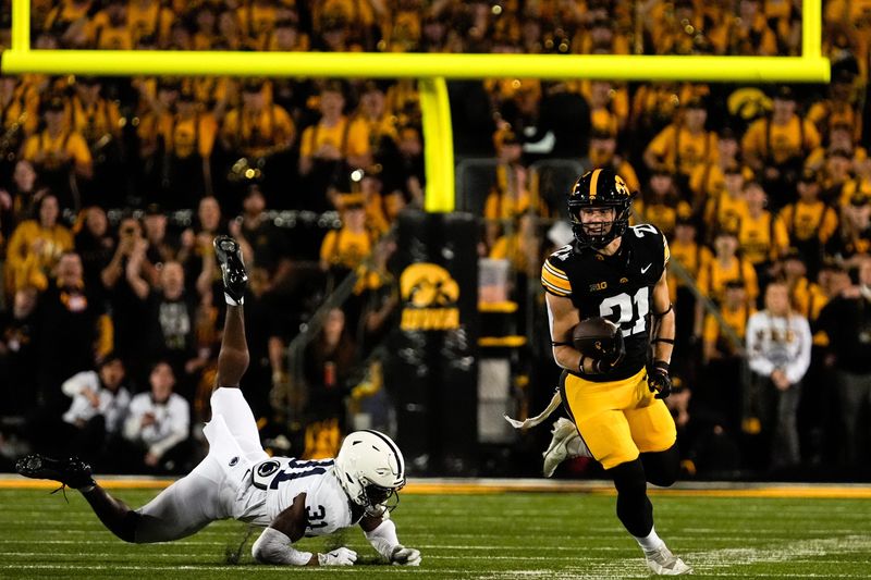Iowa Hawkeyes wide receiver Kaden Wetjen (21) returns a punt as Penn State Nittany Lions safety Kolin Dinkins (31) defends during a college football game Oct. 18, 2025 at Kinnick Stadium in Iowa City, Iowa.