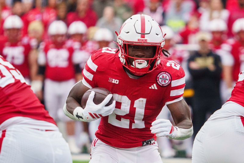 Oct 25, 2025; Lincoln, Nebraska, USA; Nebraska Cornhuskers running back Emmett Johnson (21) runs the ball against the Northwestern Wildcats during the first quarter at Memorial Stadium. Mandatory Credit: Dylan Widger-Imagn Images