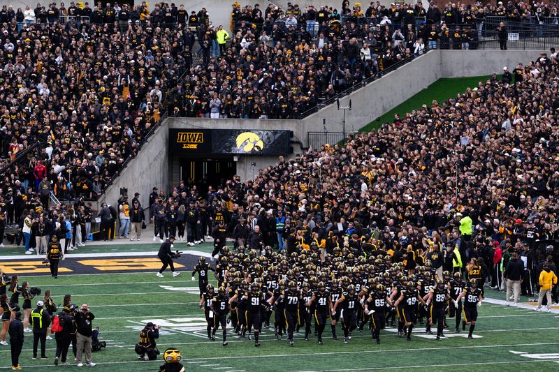 The Iowa Hawkeyes swarm onto the field ahead of a football game against the Minnesota Golden Gophers Oct. 25, 2025 at Kinnick Stadium in Iowa City, Iowa.