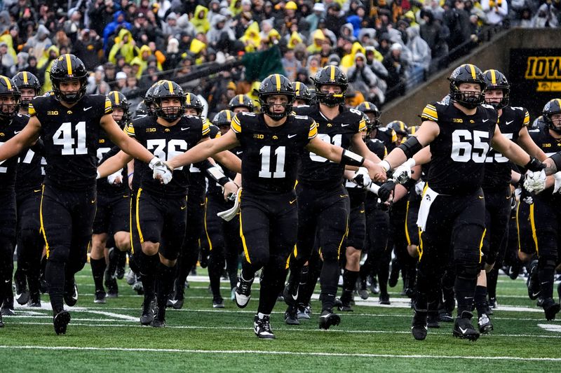 The Iowa Hawkeyes swarm onto the field Nov. 8, 2025 ahead of a Big Ten Football game against the Oregon Ducks at Kinnick Stadium in Iowa City, Iowa.