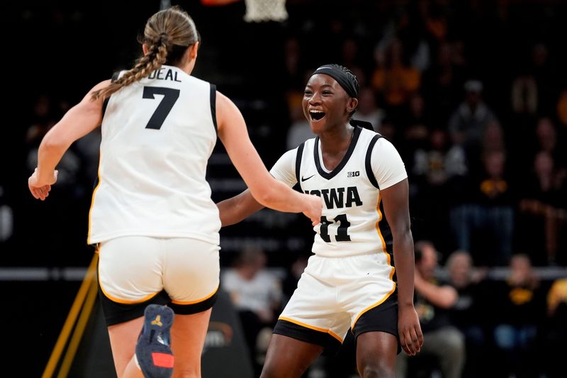 Iowa guard Chazadi 'Chit-Chat' Wright (11) high-fives Iowa guard Addie Deal (7) after Deal made a 3-pointer Nov. 9, 2025, during a women's basketball game against the Evansville Purple Aces at Carver-Hawkeye Arena in Iowa City, Iowa.