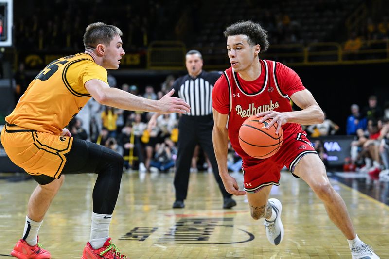 Nov 18, 2025; Iowa City, Iowa, USA; Southeast Missouri State Redhawks guard Jay Reynolds (25) controls the ball as Iowa Hawkeyes guard Brendan Hausen (15) defends during the first half at Carver-Hawkeye Arena. Mandatory Credit: Jeffrey Becker-Imagn Images