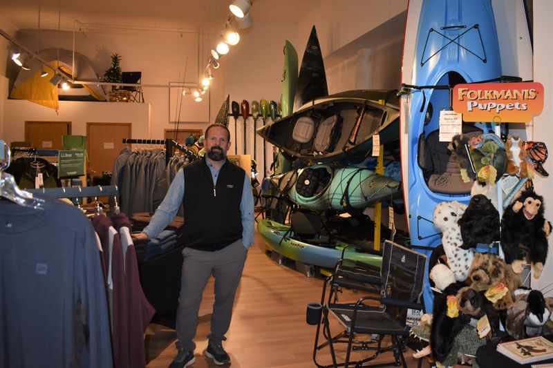 Jamie Borglum, who owns CrawDaddy Outdoors with his wife Renee Borglum, poses by the kayaks at the store, located at 327 Main St. in downtown Ames.