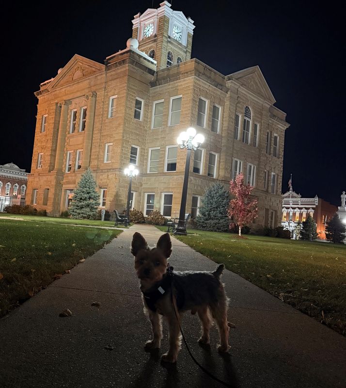 Watson is seen standing by the 1903 Romanesque-style Monroe County Courthouse, part of the Albia Square and Central Commercial Historic District, listed on the National Register of Historic Places since 1985.