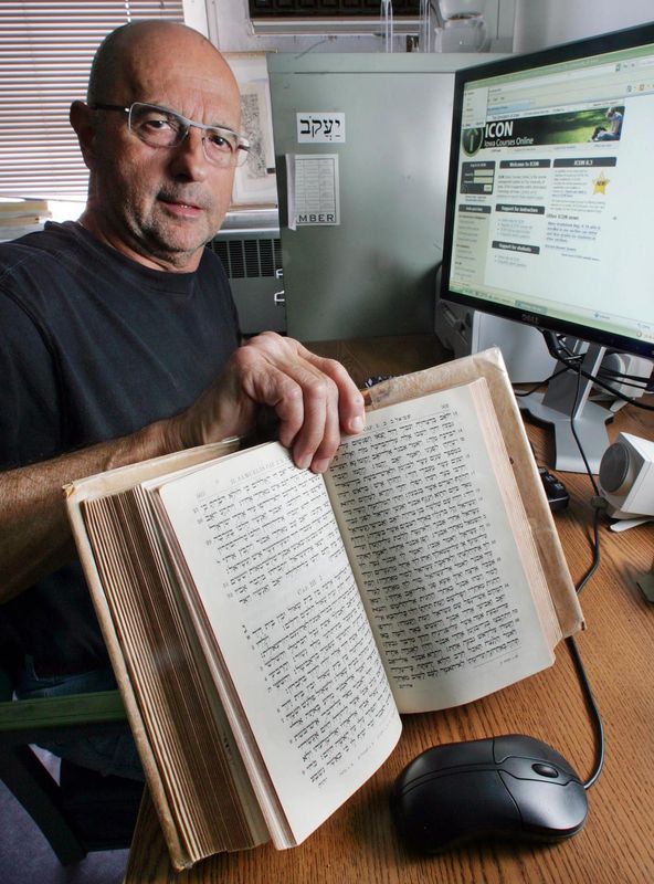 Religious studies professor Jay Holstein kept a century-old Hebrew Bible in his office at the University of Iowa, where he taught a combination of on-campus and online courses in this 2008 photo.