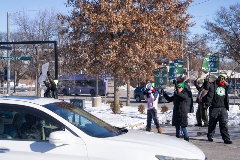 Potential customers turn away from the drive through lane as striking baristas picket the Starbucks on Merle Hay Road in Des Moines on Thursday, Dec. 4.