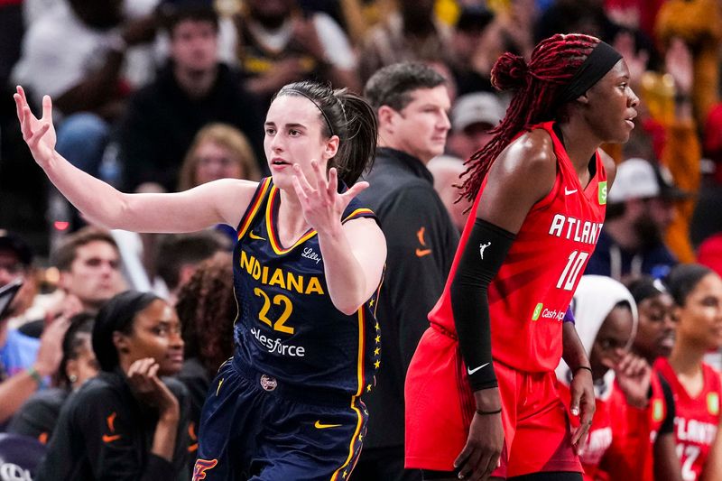 Indiana Fever guard Caitlin Clark (22) reacts after scoring a 3-pointer against Atlanta Dream guard Rhyne Howard (10) on Tuesday, May 20, 2025, during a game between the Indiana Fever and the Atlanta Dream at Gainbridge Fieldhouse in Indianapolis.