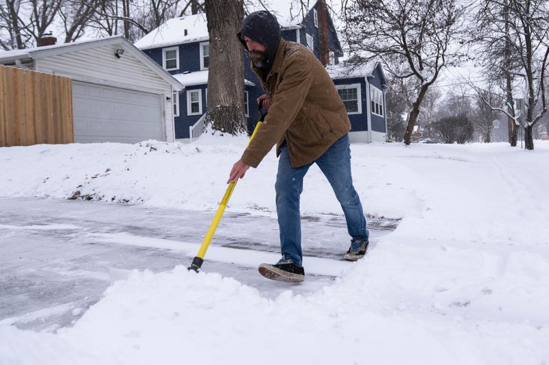 Aaron Ramsey shovels snow in his driveway as snow falls in the metro area on Saturday, Dec. 13, 2025, in Des Moines.
