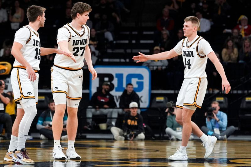 Iowa guard Bennett Stirtz (14) and Iowa guard Brendan Hausen (15) high-five Iowa center Trevin Jirak (27) during a game against the Western Michigan Broncos Dec. 14, 2025 at Carver-Hawkeye Arena in Iowa City, Iowa.