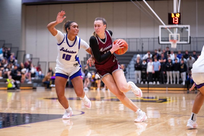 Dowling’s Katie Muller (11) drives to the basket against Johnston's Jenica Lewis (10) on Dec. 16, 2025, at Johnston High School.