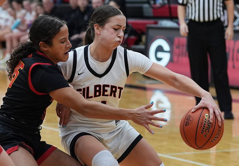 Gilbert guard Callie Hales (11) drives with the ball as Carlisle's Alyvia Freeman (15) defends during the first quatert of girls basketball on Dec. 19, 2025, at Gilbert High School gym in Gilbert, Iowa