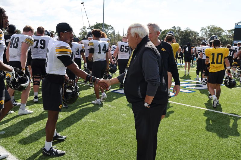 Longtime NFL assistant coach Tom Moore, who was a graduate assistant at Iowa in 1961-62 and currently is a consultant with the Tampa Bay Buccaneers, spoke to the Iowa team and here is shown with wide receiver Jacob Gill on Dec. 27, 2025.
