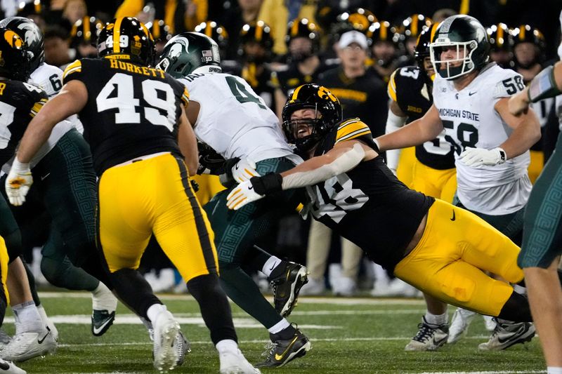 Iowa Hawkeyes defensive end Max Llewellyn (48) tackles Michigan State Spartans running back Elijah Tau-Tolliver (4) Nov. 22, 2025 at Kinnick Stadium in Iowa City, Iowa.