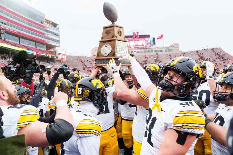 Nov 28, 2025; Lincoln, Nebraska, USA; The Iowa Hawkeyes hoist the Heroes Trophy after defeating the Nebraska Cornhuskers at Memorial Stadium. Mandatory Credit: Dylan Widger-Imagn Images