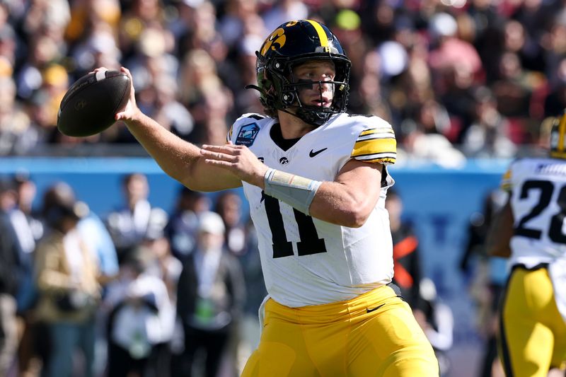 Dec 31, 2025; Tampa, FL, USA; Iowa Hawkeyes quarterback Mark Gronowski (11) throws a pass against the Vanderbilt Commodores in the first quarter during the ReliaQuest Bowl at Raymond James Stadium. Mandatory Credit: Nathan Ray Seebeck-Imagn Images