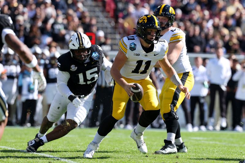 Dec 31, 2025; Tampa, FL, USA; Iowa Hawkeyes quarterback Mark Gronowski (11) scrambles out of the pocket against the Vanderbilt Commodores in the first quarter during the ReliaQuest Bowl at Raymond James Stadium. Mandatory Credit: Nathan Ray Seebeck-Imagn Images