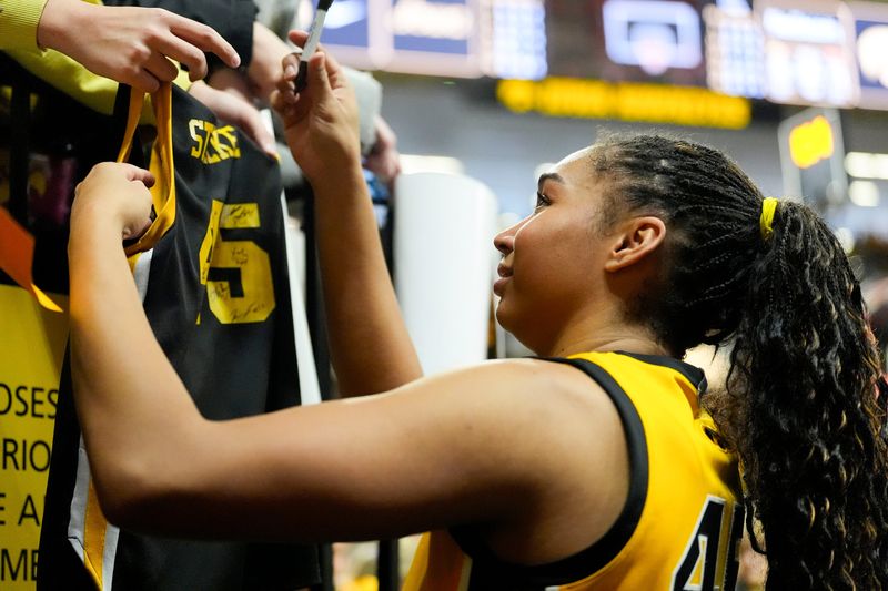 Iowa forward Hannah Stuelke (45) signs a fan jersey with her name on it after the Hawkeyes defeated the Nebraska Cornhuskers Jan. 1, 2026 at Carver-Hawkeye Arena in Iowa City, Iowa.