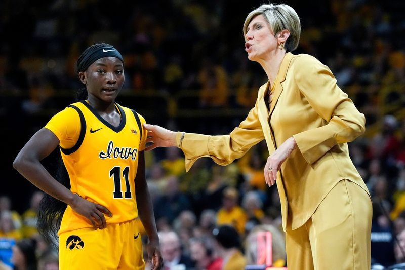 Iowa guard Chit-Chat Wright (11) talks with Iowa head coach Jan Jensen during a game against the Nebraska Cornhuskers on Jan. 1, 2026, at Carver-Hawkeye Arena in Iowa City, Iowa.