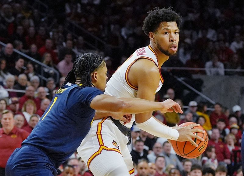 Iowa State Cyclones forward Joshua Jefferson (5) looks for a pass around West Virginia Mountaineers forward Evans Barning Jr. (7) during the first half on Jan. 2, 2026, at Hilton Coliseum in Ames, Iowa.