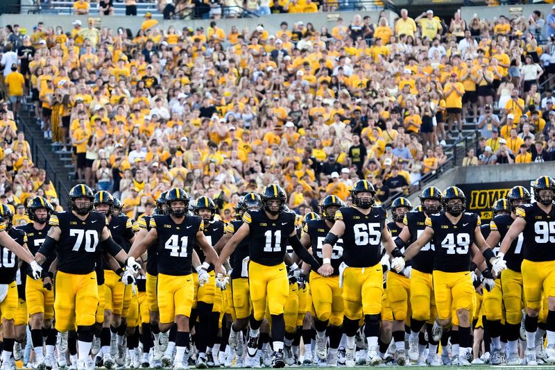 The Iowa Hawkeyes swarm onto the field before the football game against the Massachusetts Minutemen Sept. 13, 2025 at Kinnick Stadium in Iowa City, Iowa.