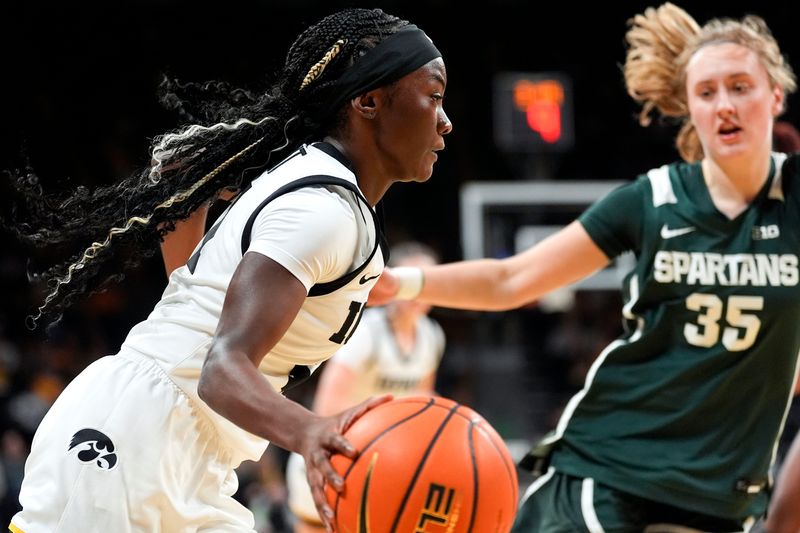 Iowa guard Chit-Chat Wright (11) drives toward the basket as Michigan State guard Kennedy Blair (35) defends Jan. 18, 2026 at Carver-Hawkeye Arena in Iowa City, Iowa.