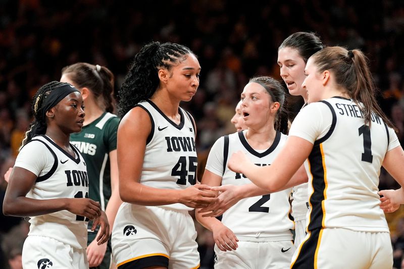 Iowa's Chit-Chat Wright (11), Hannah Stuelke (45), Taylor McCabe (2), Ava Heiden (5), and Taylor Stremlow (1) huddle during a game against the Michigan State Spartans on Jan. 18, 2026, at Carver-Hawkeye Arena in Iowa City, Iowa.