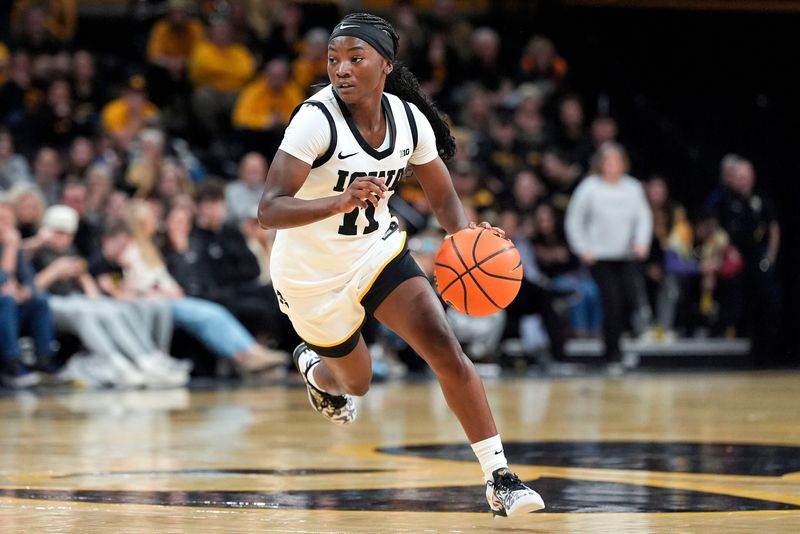 Iowa guard Chit-Chat Wright (11) dribbles around the 3-point line during a basketball game against the Michigan State Spartans on Jan. 18, 2026, at Carver-Hawkeye Arena in Iowa City, Iowa.