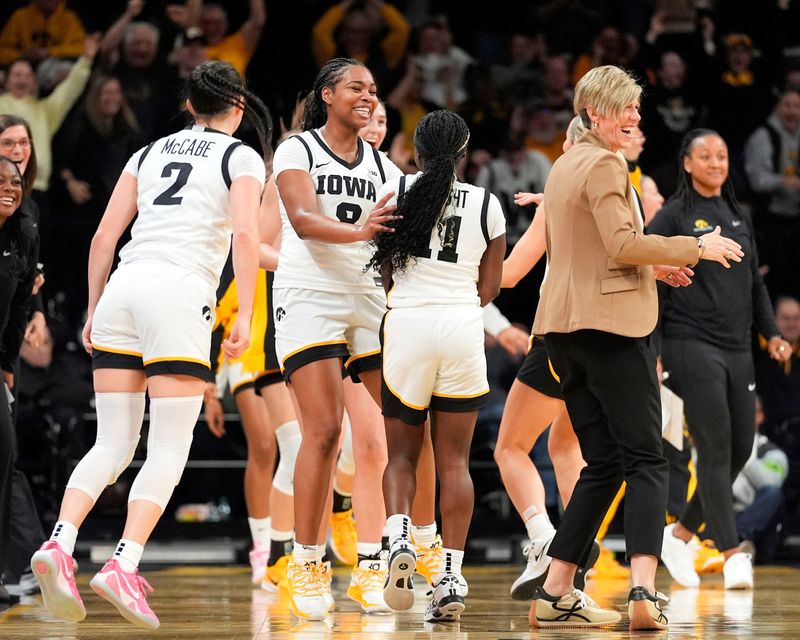 The Iowa Hawkeyes celebrate with Iowa guard Chit-Chat Wright (11) after she sinks a half-court heave at the end of the first quarter against the Michigan State Spartans Jan. 18, 2026 at Carver-Hawkeye Arena in Iowa City, Iowa.