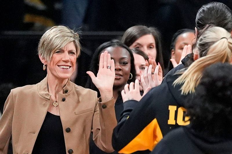 Iowa head coach Jan Jensen high-fives her players after warmups before a game against the Michigan State Spartans Jan. 18, 2026 at Carver-Hawkeye Arena in Iowa City, Iowa.