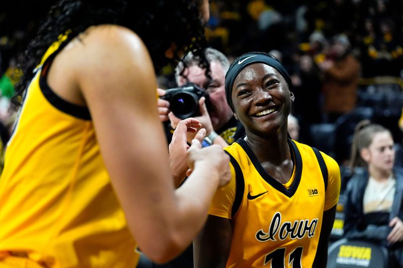 Iowa guard Chit-Chat Wright (11) talks to Iowa forward Hannah Stuelke (45) while walking off the court after defeating the Ohio State Buckeyes Jan. 25, 2026 at Carver-Hawkeye Arena in Iowa City, Iowa.