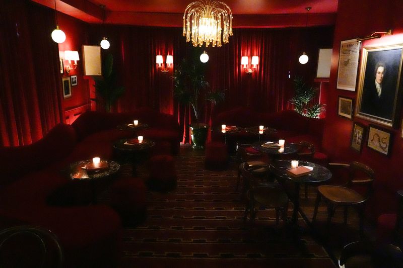 Claude, located at 215 N. Linn St., features a dark red interior and small tables lit by candlelight Jan. 22, 2026, in Iowa City, Iowa.