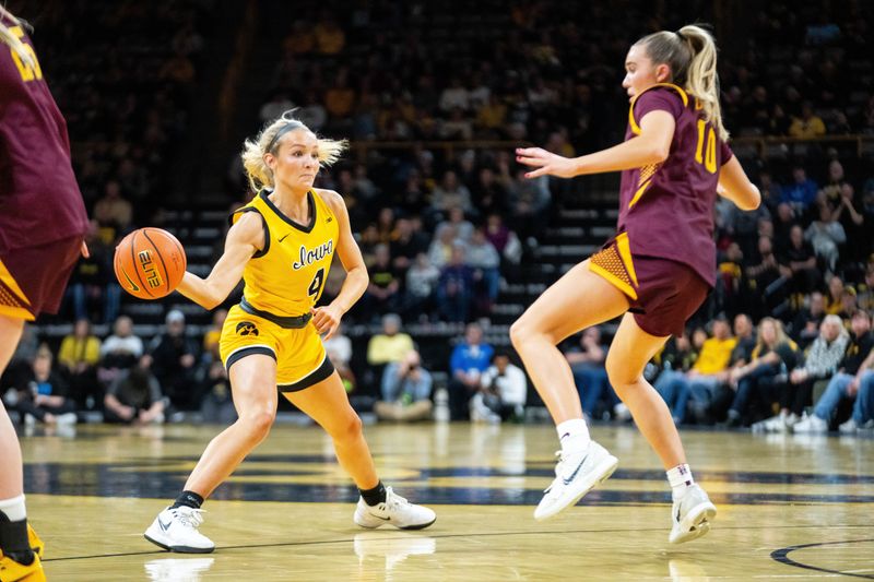 Iowa guard Kylie Feuerbach (4) passes the ball into the paint against Minnesota guard Mara Braun (10) on Feb. 5, 2026, at Carver-Hawkeye Arena.