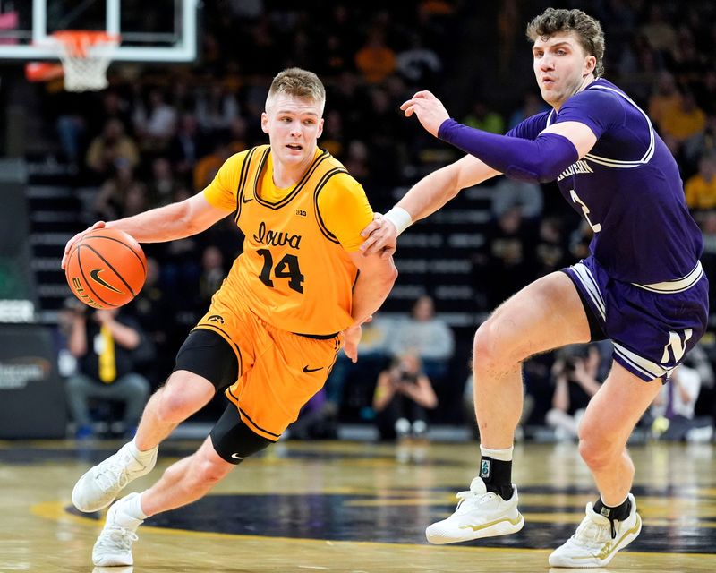 Iowa guard Bennett Stirtz (14) drives toward the basket as Northwestern forward Nick Martinelli (2) defends Feb. 8, 2026 at Carver-Hawkeye Arena in Iowa City, Iowa.